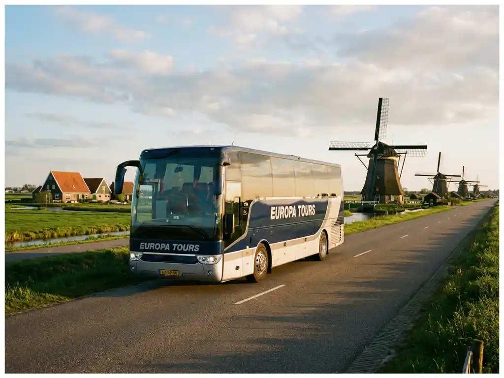 Grote touringcar rijdt door Nederlands platteland met traditionele windmolens en groene polders op de achtergrond