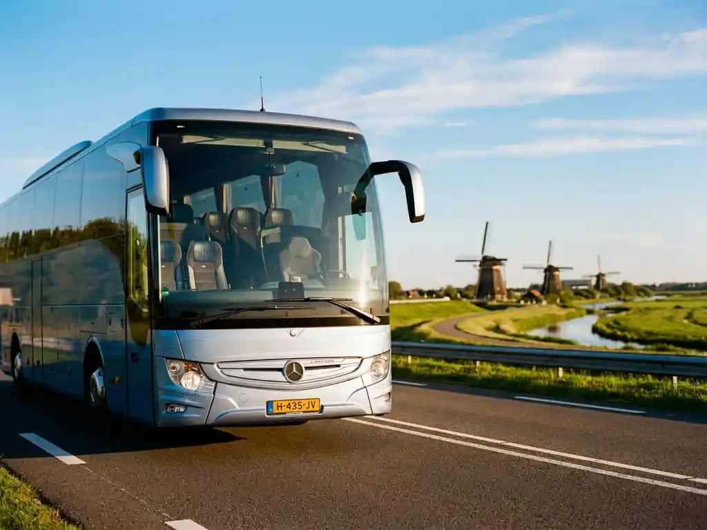 Grote moderne touringcar rijdt over Nederlandse snelweg met windmolens en groene polders op de achtergrond