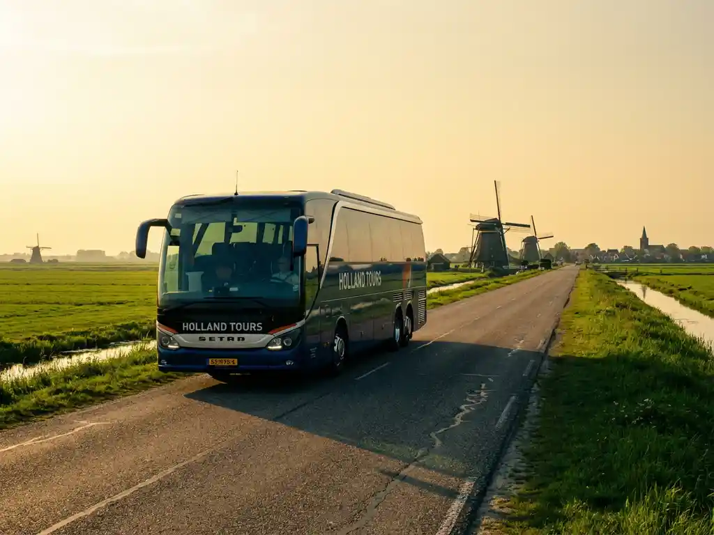 Moderne touringcar rijdt door Nederlands landschap met traditionele windmolens en groene polders in gouden middaglicht