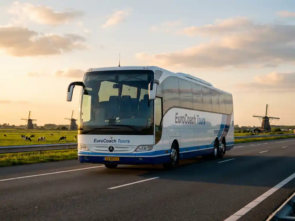 Grote witte en blauwe touringcar rijdt over Nederlandse snelweg met traditionele windmolens en groene polders op achtergrond