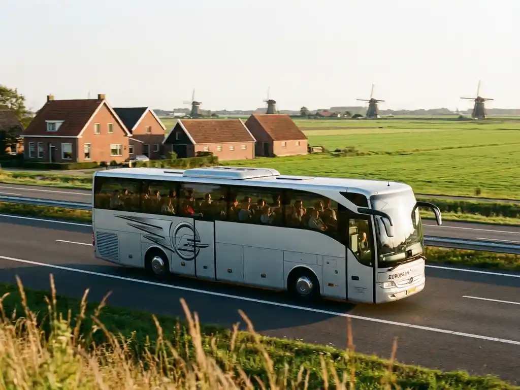 Moderne touringcar rijdt over Nederlandse snelweg met traditionele boerderijen en molens in het landschap