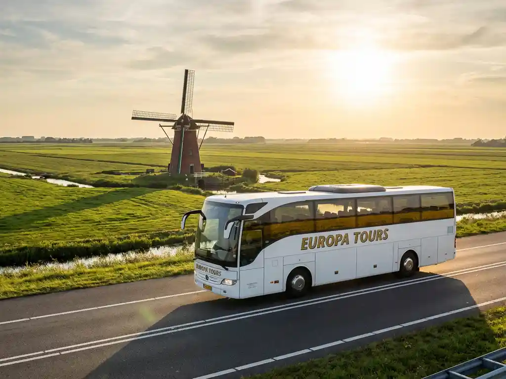 Witte touringcar rijdt over Nederlandse snelweg met traditionele rode bakstenen windmolen in groene polderlandschap