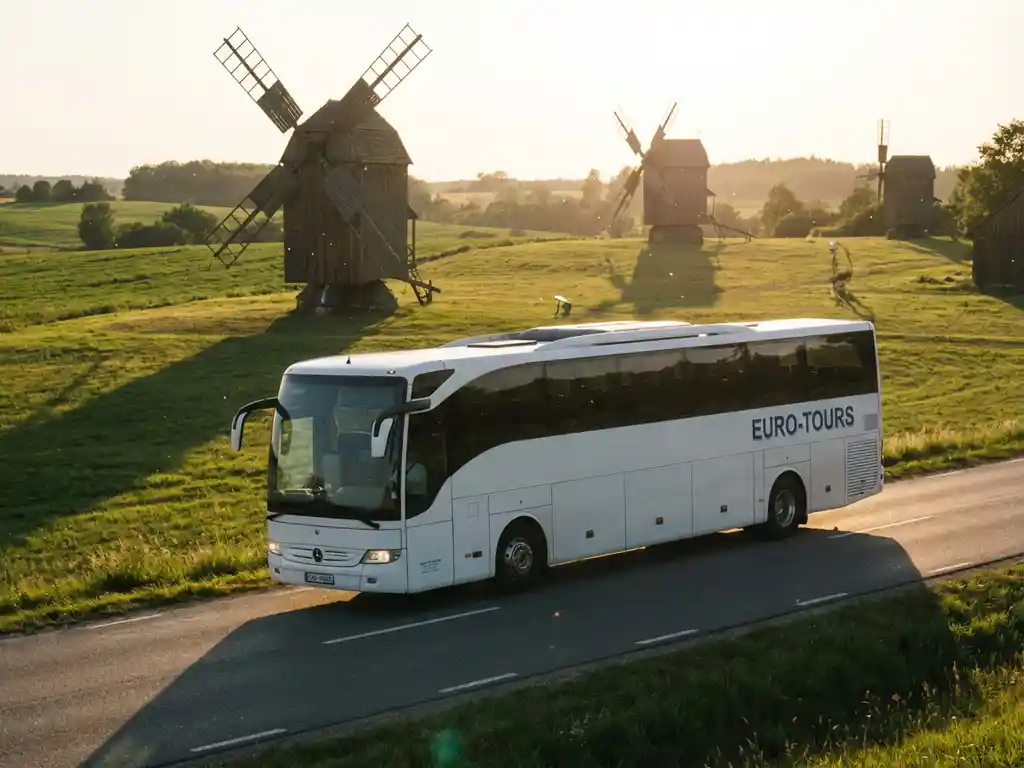 Witte touringcar rijdt door Nederlands landschap met traditionele windmolens en groene velden in gouden middaglicht