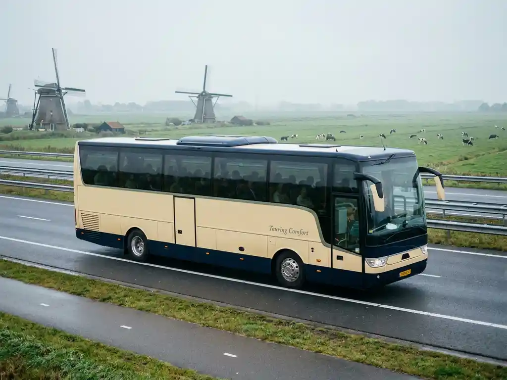 Moderne touringcar rijdt over Nederlandse snelweg met windmolens en groene polders op de achtergrond.