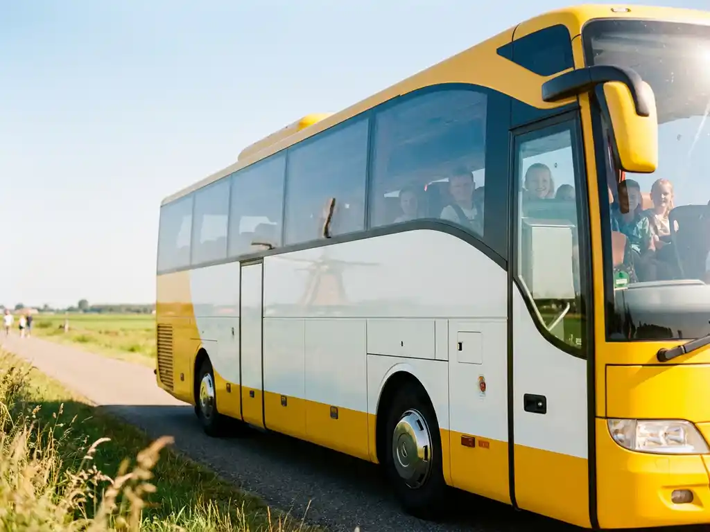 Gele touringcar met schoolkinderen rijdt over een Nederlandse polderdijk, met groene weilanden en een windmolen op de achtergrond.