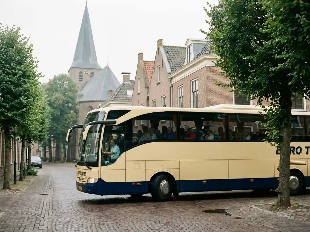 Moderne touringcar met passagiers rijdt door een rustig Nederlands dorpsstraatje met bakstenen gevels en kerktorenspitsen op de achtergrond.